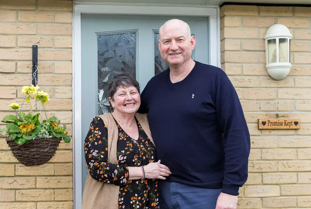 A happy couple outside their home they got with Your Home