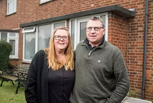 A couple outside their home bought with Your Home